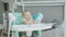 Cute baby girl sitting on highchair licking plate