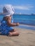 Cute baby girl in a whitee hat sitting