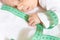 Cute baby infant boy hold green centimeter in hand