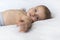 Cute baby is lying quietly on the bed in the bedroom on a white blanket The little boy has been resting for nine months. White