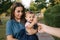 Cute baby on mom`s hands outside. Family in the park in summer. Denim style. Mom and daughter in jeans