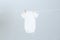 Cute baby onesie hanging on clothes line against light grey background