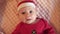 Cute Baby Santa lying in a suit of Santa Claus, in a red hat, red pajamas. Christmas concept. Volunteer baby Santa