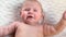 Cute baby Sneezing and smiles at the camera close-up Head and Face. Cute Newborn Baby Sneezes and Smiling. Motherhood