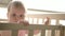 Cute baby standing in cot. Cute childhood. Toddler girl in crib