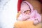 Cute baby in stroller on frosty winter day. Baby wearing woolen warm hat and mittens and lying in lama fur coated red stroller. 1