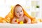 Cute baby with toys under a hooded towel after bath