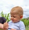 A cute baby tries eating lemon and makes a sour face at a vineyard