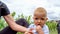 A cute baby tries eating lemon and makes a sour face at a vineyard