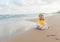 Cute baby wearing a yellow cartoon bathrobe sitting and playing on the beach near the sea