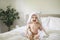 A cute Baby in white bedding at home