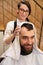 Cute barber dries the hair of client with soft towel