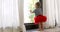 Cute barefoot baby girl in red skirt looking at window