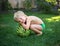 Cute barefoot toddler boy sits near a large striped watermelon