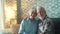 Cute and beautiful couple of old people smiling and looking at the camera having fun at home together. Portrait of seniors sitting