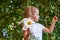 Cute beautiful girl with flower holding a big white chamomile flower. Child in nature in the grass.