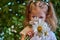 Cute beautiful girl with flower holding a big white chamomile flower. Child in nature in the grass.