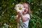 Cute beautiful girl with flower holding a big white chamomile flower. Child in nature in the grass.