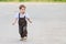 Cute beautiful little boy in brown suit, walks