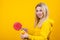 Cute beautiful young blonde woman in casual yellow sporty clothes play ping pong, holding a ball and racquet