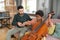 Cute biracial boy playing cello while sitting next to his teacher