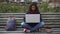 Cute biracial girl carried away by exciting research project sitting in park