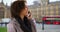 Cute black female chats happily on mobile device near Palace of Westminster