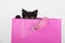 Cute black kitten peeking out of gift bag present