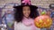 Cute black teen girl in witch hat posing faces on Halloween