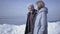 Cute blond bearded man walking with pretty woman holding hands. Amazing view of a snowy North or South Pole on the