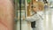 A cute blond boy of two years is considering a store through the glass. The kid carefully examines the inside of the