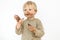 Cute blond dirty toddler eating chocolate bar with great pleasure