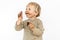 Cute blond dirty toddler eating chocolate bar with great pleasure