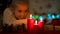 Cute blond girl looking at burning candles on Christmas eve, waiting for magic