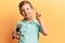 Cute blond kid singing song using microphone smiling with an idea or question pointing finger with happy face, number one