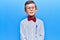 Cute blond kid wearing nerd bow tie and glasses with a happy and cool smile on face