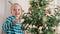 Cute blond preschool girl decorating christmas tree. Authentic family xmas time