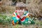 Cute blond preschool kid boy discovering first spring flowers, beautiful snowdrops