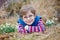 Cute blond preschool kid boy discovering first spring flowers, beautiful snowdrops