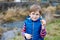 Cute blond preschool kid boy discovering first spring flowers, beautiful snowdrops