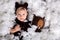 Cute blond toddler boy in knitted bear overall, holding teddy bear toy