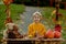 Cute blond toddler child and sibling brothers, standing next to autumn wooden stand with decoration, apples, leaves, mug,