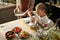 Cute blond youthful girl with white duster wiping clean plates after washing