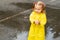 Cute blonde baby girl toddler wearing yellow stylish raincoat closeup. childhood.