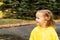 Cute blonde baby girl toddler wearing yellow stylish raincoat closeup. childhood.