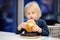 Cute blonde boy eat hamburger at fast food restaurant