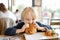 Cute blonde boy eating large hamburger at fastfood restaurant. Unhealthy meal for kids. Junk food