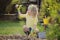 Cute blonde child girl having fun playing little gardener