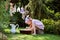 Cute blonde child girl plays toy wash in summer garden