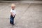 Cute blonde kid looking looking back. Awesome baby boy on the walk. Copy space